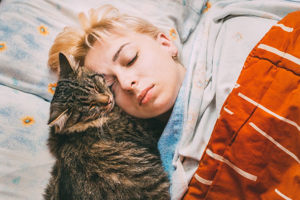 woman-sleeping-with-her-cat