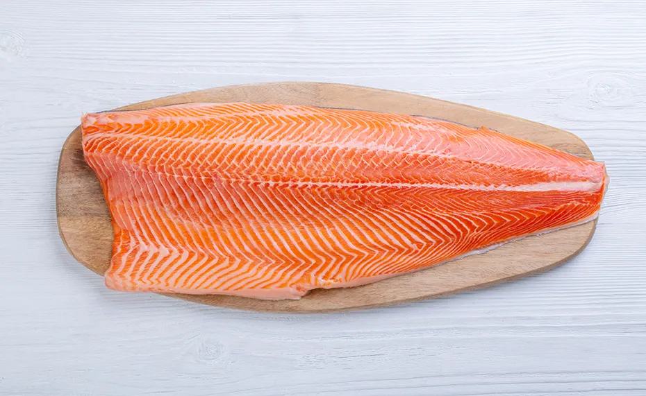 Half raw salmon fillet on the table