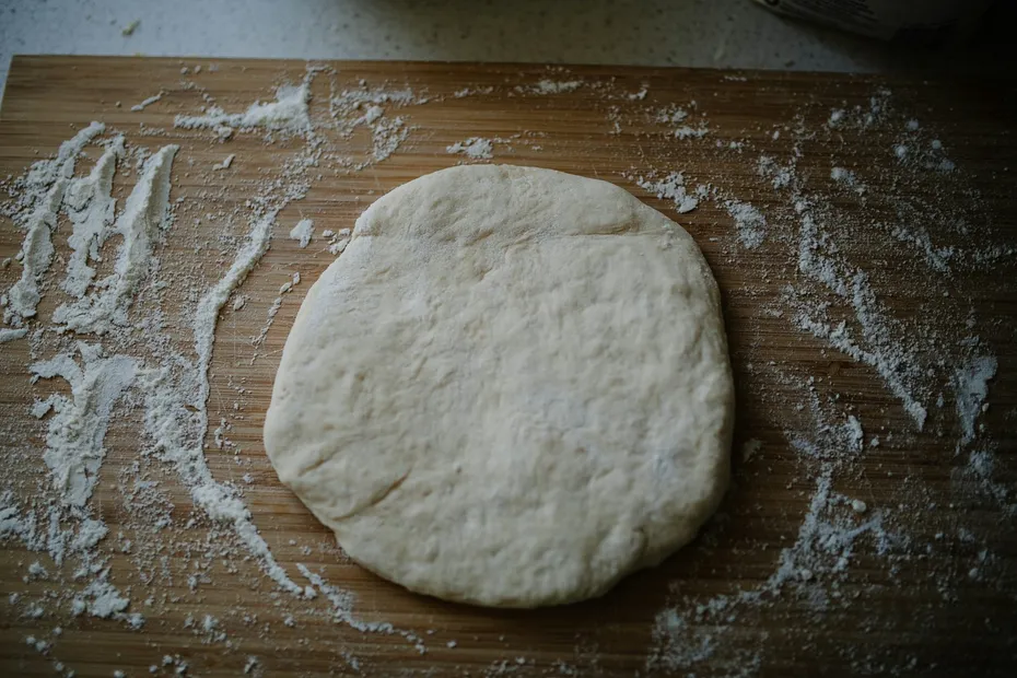 white pizza dough on brown wooden table