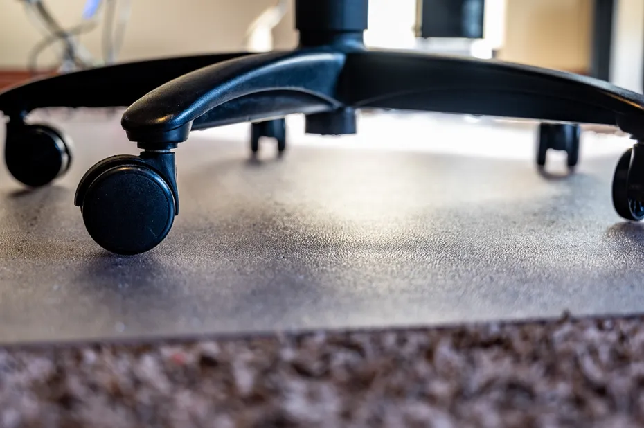 Selective focus on transition between carpet and hard protective mat for a home office rolling desk chair