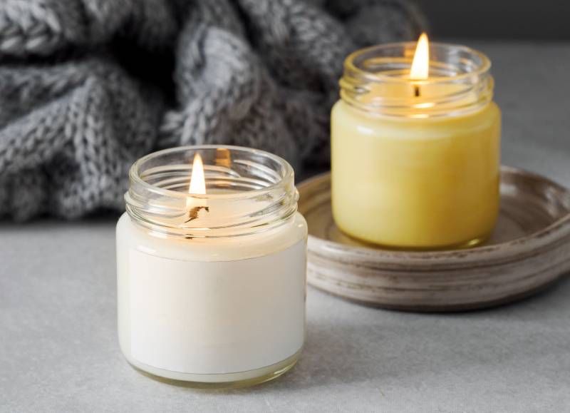 two lit candles in a jar
