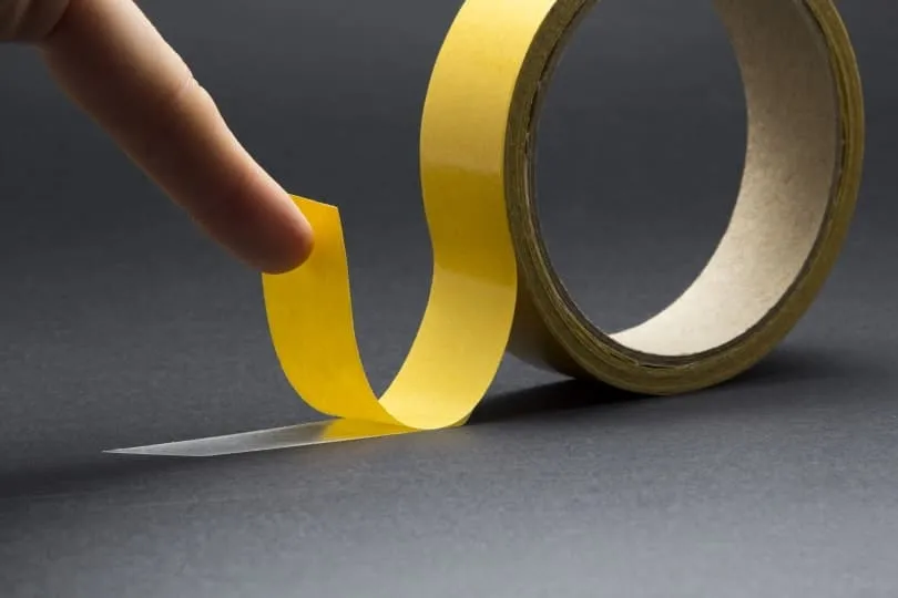 mans-finger-touches-double-sided-tape