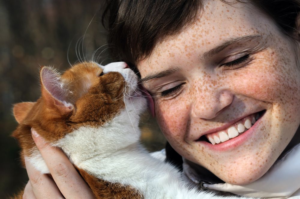 Cat licking a woman's face