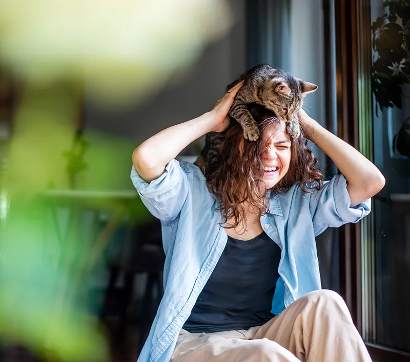 young woman playing with her cat