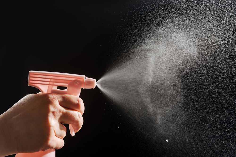 hand spraying water from a bottle