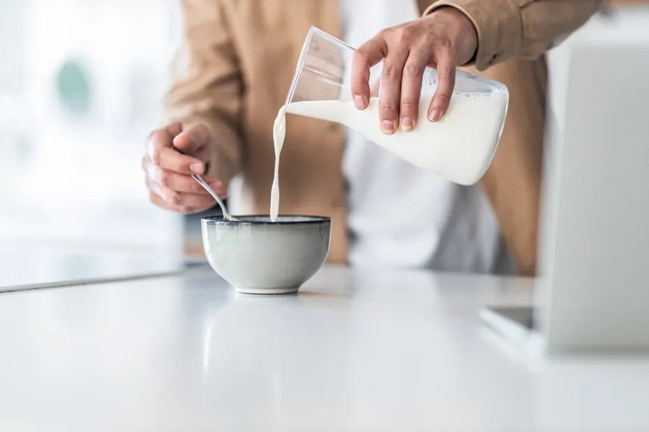 Man pouring fresh milk into a bowl
