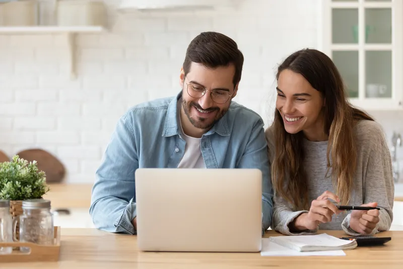 young couple reading good news in email on laptop