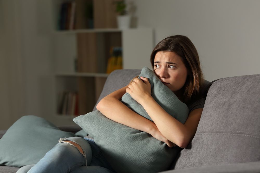 Scared womand hugging a pillow