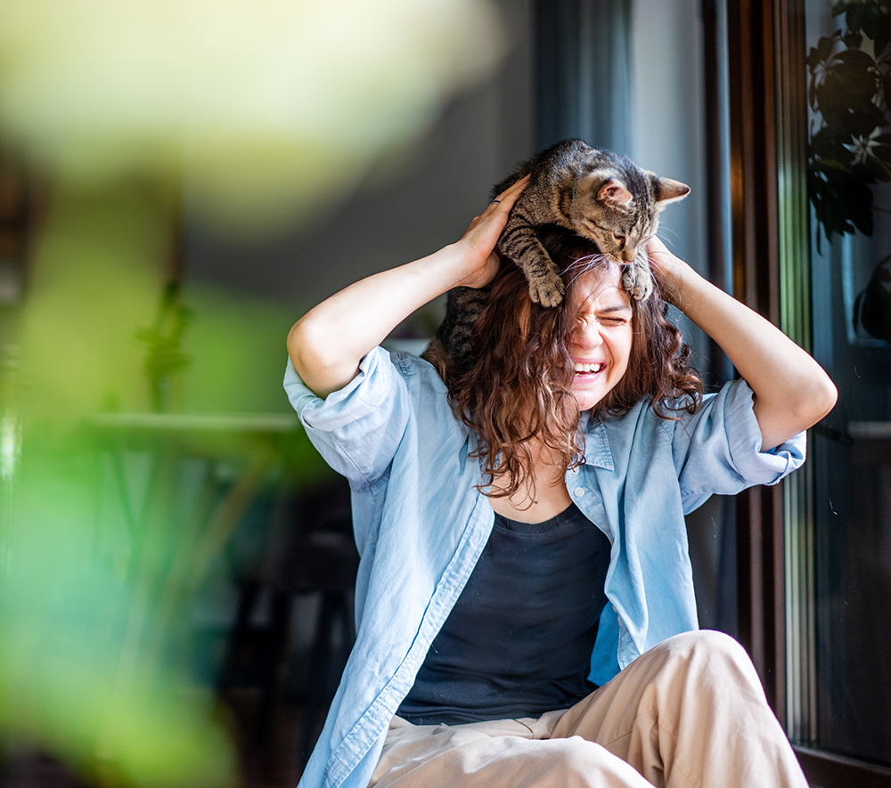 young woman playing with her cat