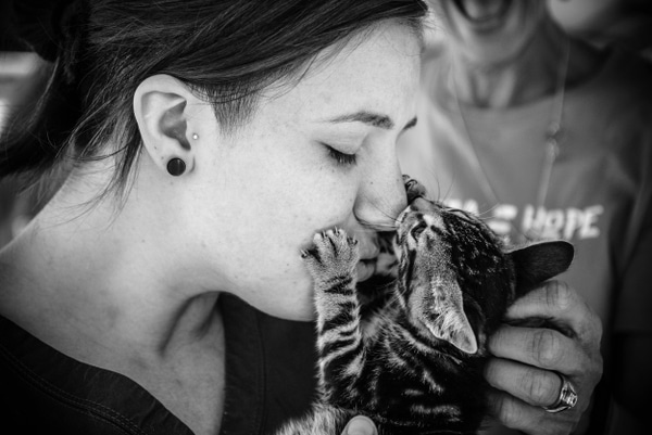 A woman kissing a kitten.