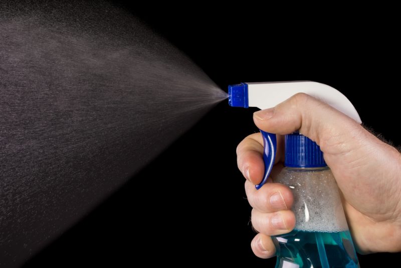 person spraying the cleaner