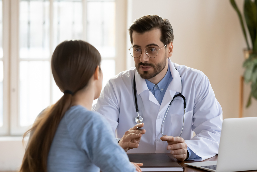 male doctor in white medical uniform talk discuss results or symptoms with female patient