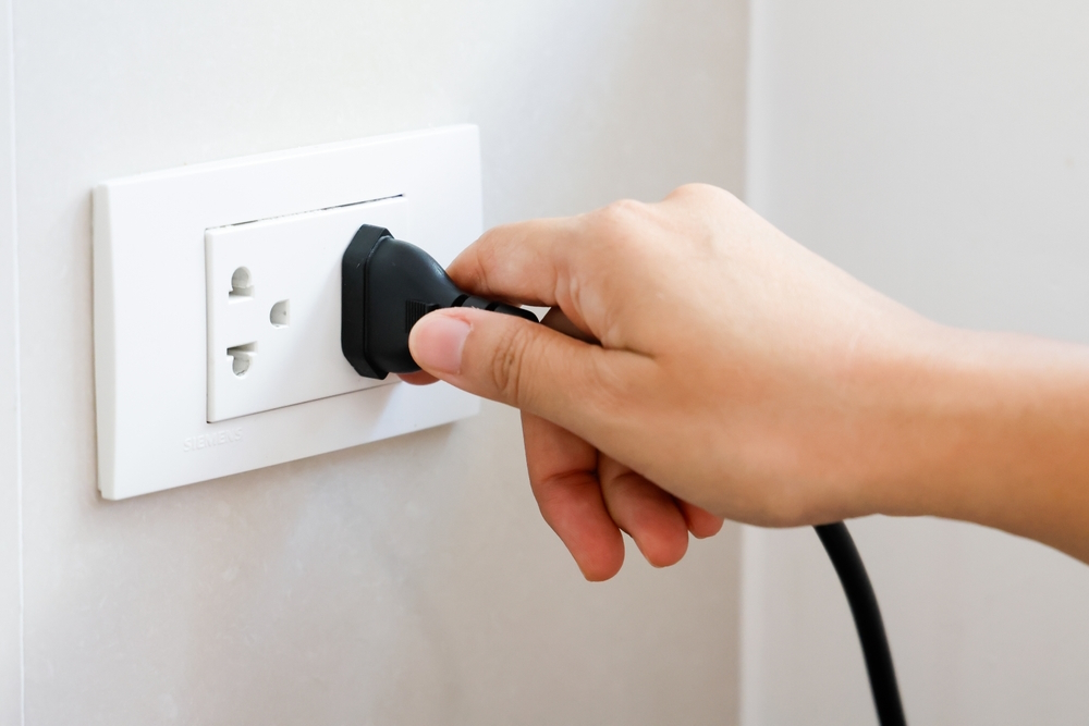 Hand-holding-plug-connect-to-a-electrical-outlet